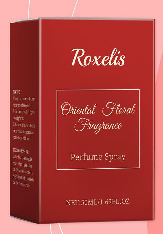 Roxelis perfume spray and packaging with a woman wearing a straw hat and pink flower on a pink background