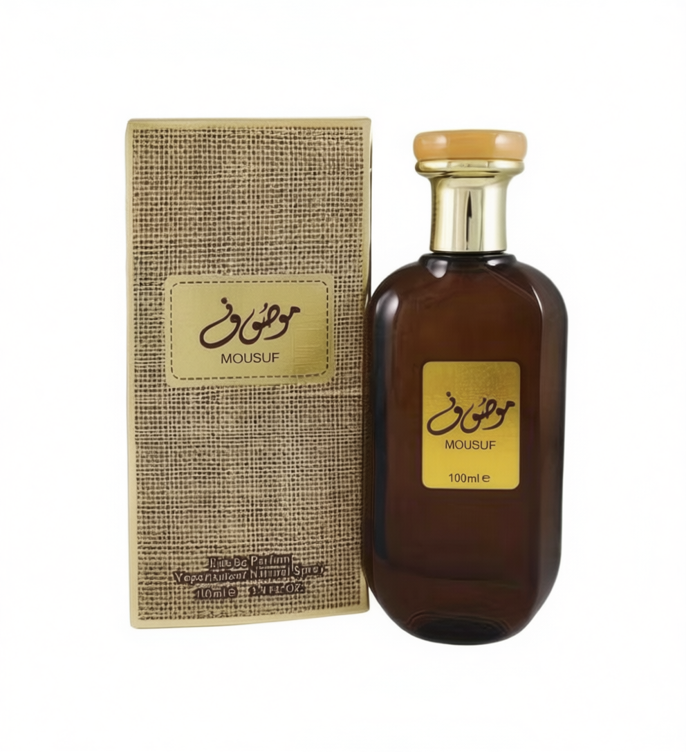 Mousuf perfume bottle and matching box. The bottle is made of dark amber glass with a gold cap and a gold label featuring Arabic calligraphy and the brand name 'MOUSUF'.