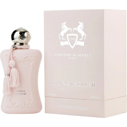 A pale blush pink perfume bottle with a silver spherical cap and pink tassel, shown next to its matching pale pink box. The box is branded Parfums de Marly Paris and reads Delina Exclusif Edition Royale.