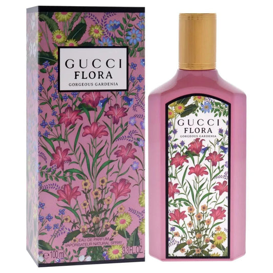Gucci Flora Gorgeous Gardenia perfume bottle and its matching outer packaging box, both decorated with a vibrant pink floral pattern and featuring a gold cap.