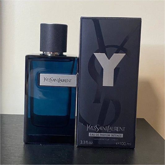 Yves Saint Laurent Eau de Parfum Intense bottle in dark blue glass next to its black packaging box with a large silver Y logo.